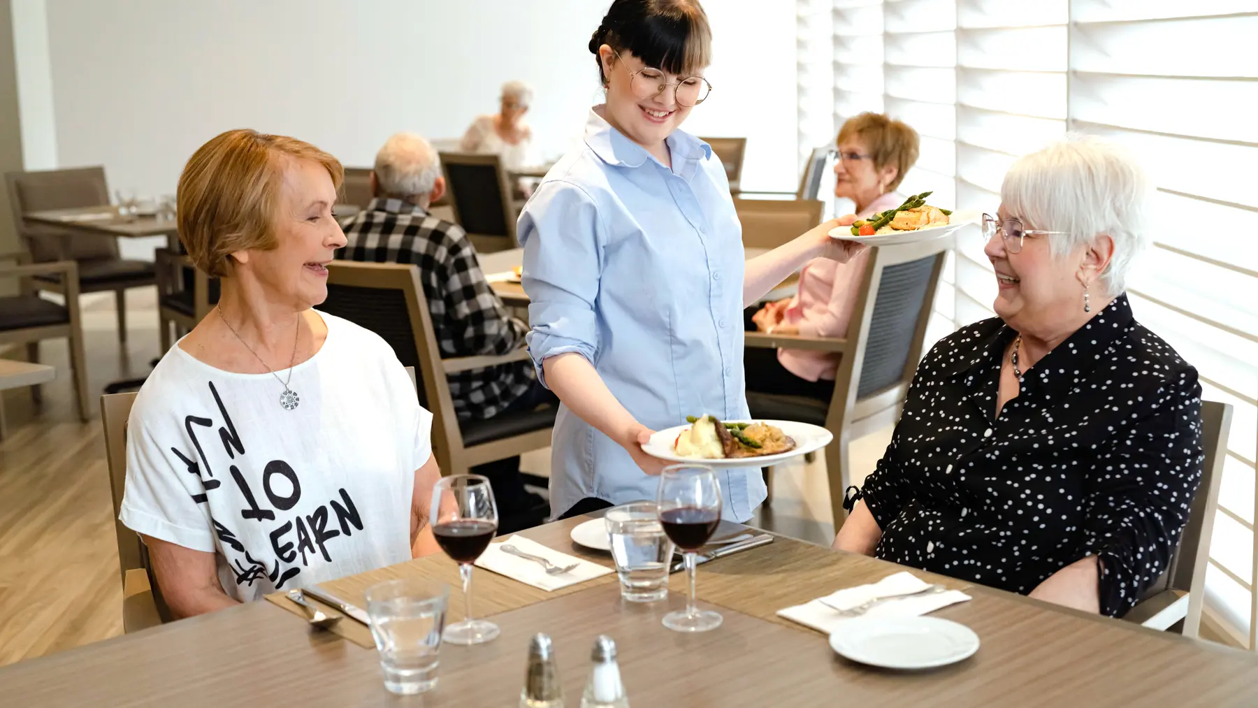 Chartwell staff server serving food to the Chartwell senior residents in Dinning room