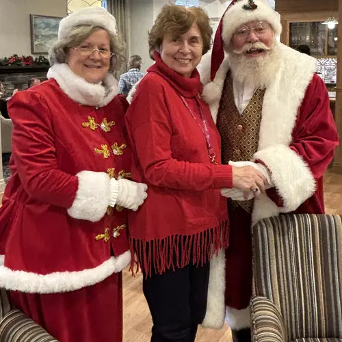 Jill and Rianne posing with Santa Claus during a holiday celebration in a retirement residence