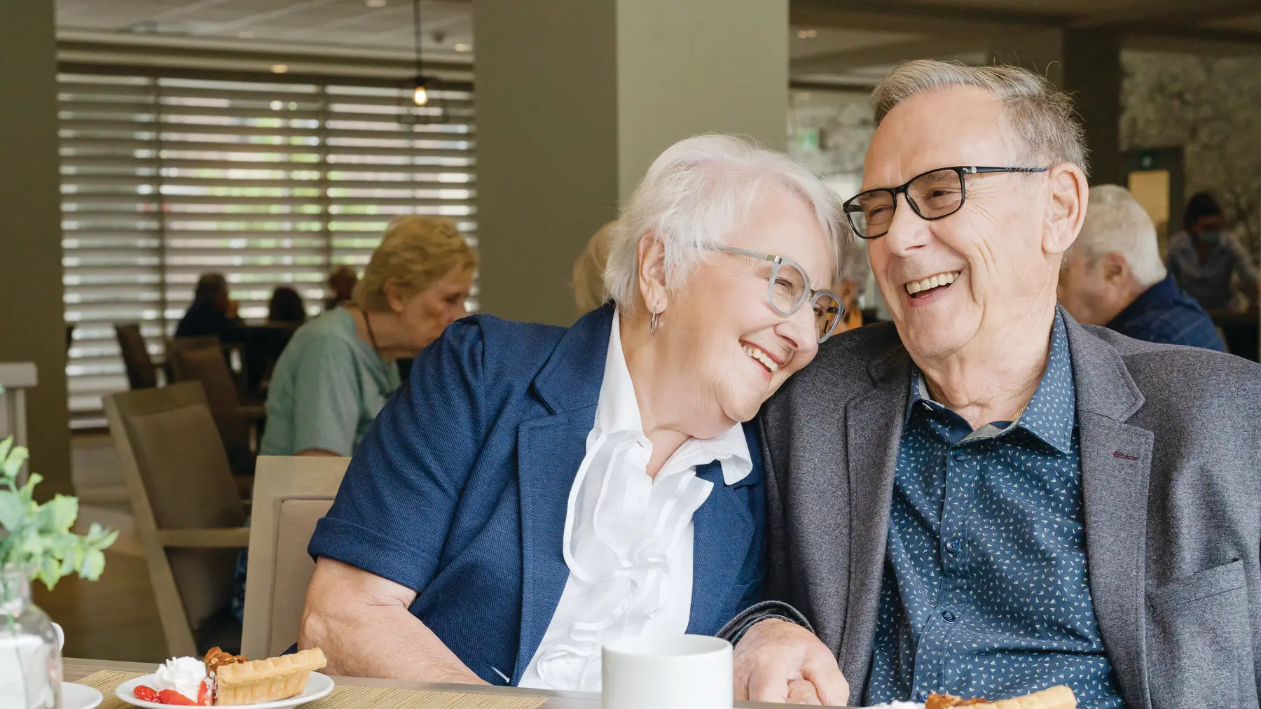 Chartwell senior couple chatting and enjoying dessert and coffee / Un couple âgé de Chartwell discutant et dégustant un dessert et un café