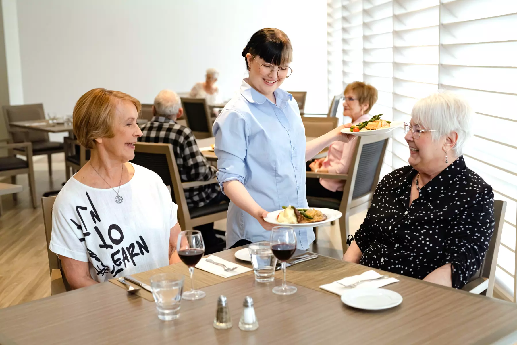 Chartwell staff server serving food to the Chartwell senior residents in Dinning room