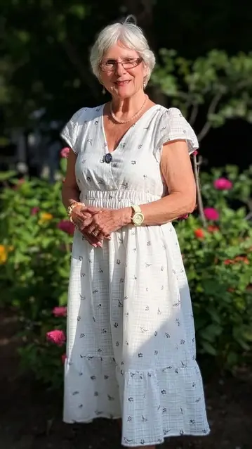 Agathe, résidente de Chartwell Rosemont Les Quartiers, dans un jardin fleuri