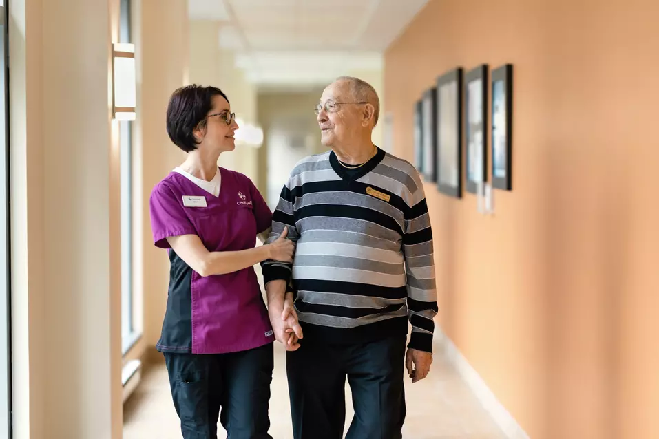 Nurse with senior man walking together