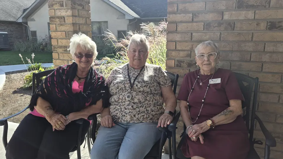 Shirley and fellow residents seated together outdoors at Chartwell Oak Park Terrace.