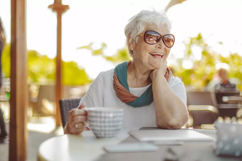 Senior woman with a big smile is enjoying her time at outdoor patio