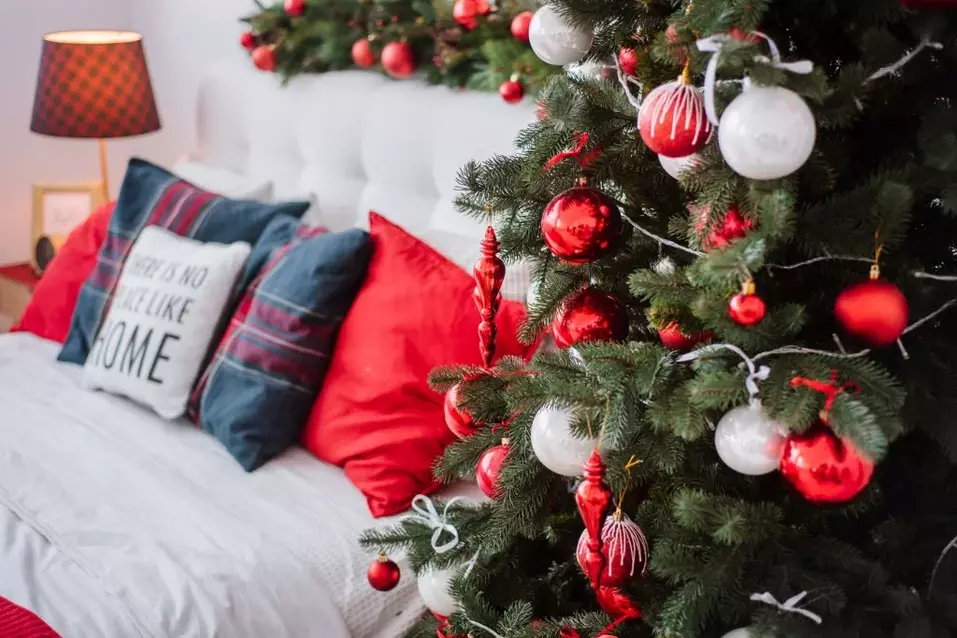 Une chambre à coucher à l'allure festive avec un sapin de Noël et des objets aux couleurs de Noël