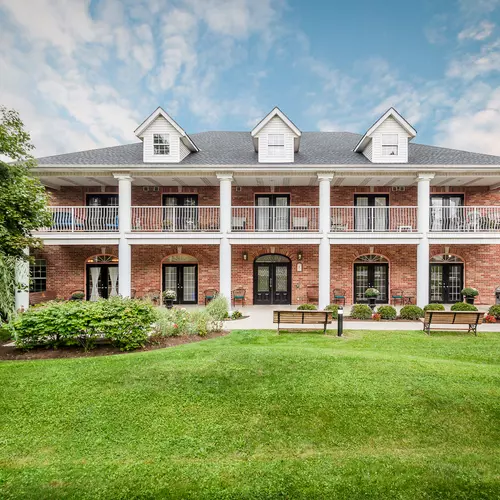 Gorgeous front of building with gardens and patio at Chartwell Georgian Retirement Residence.